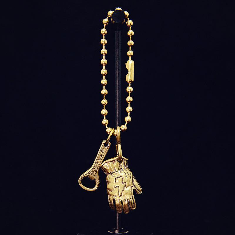 Vintage motorcycle glove keychain with brass-style finish