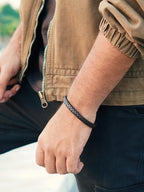 Black braided leather bracelet worn on wrist